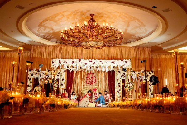 Luxury wedding theme decoration with elegant floral mandap, grand chandelier, candle-lit aisle, and traditional wedding ceremony.